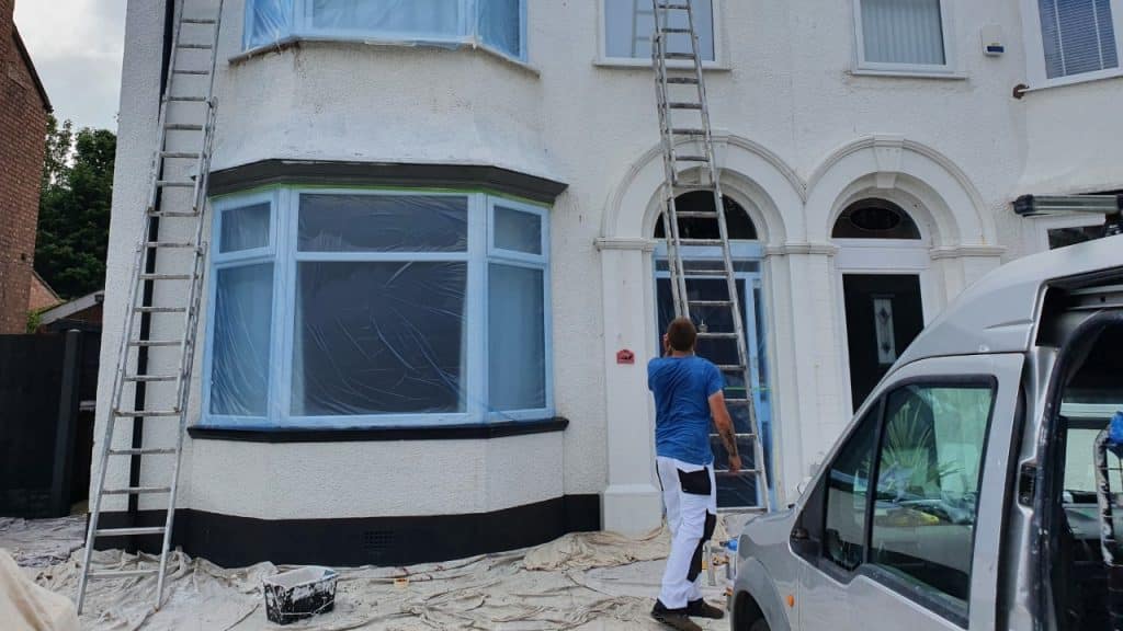 professional decorators painting the front of a building