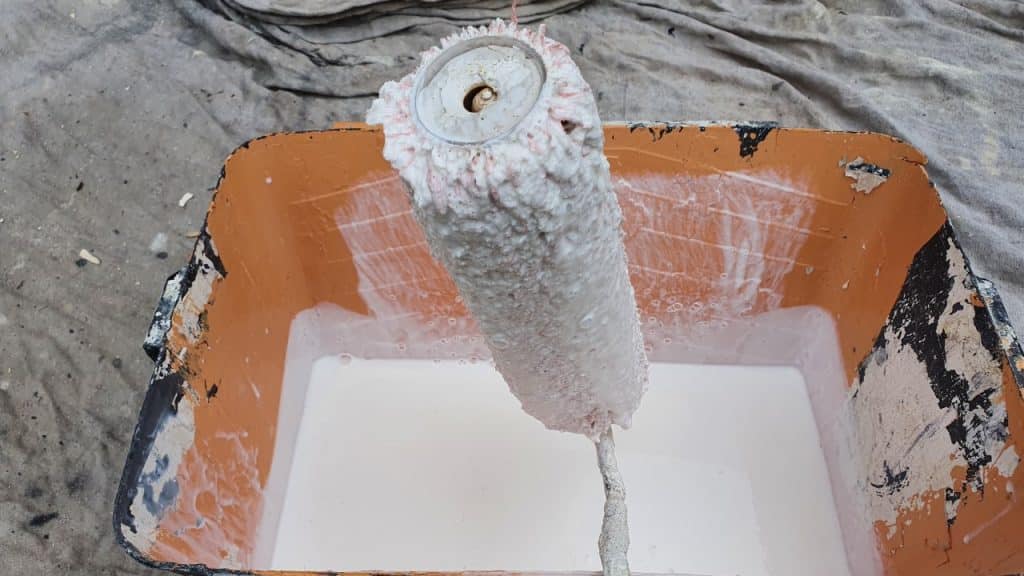 a paint roller and scuttle