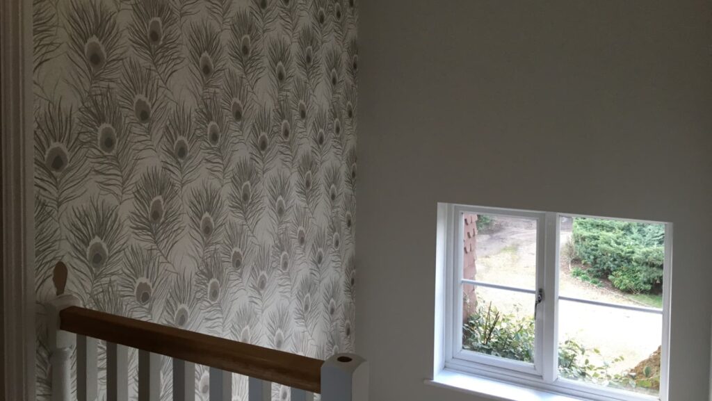 Wallpaper on a wall that was previously bare plaster.