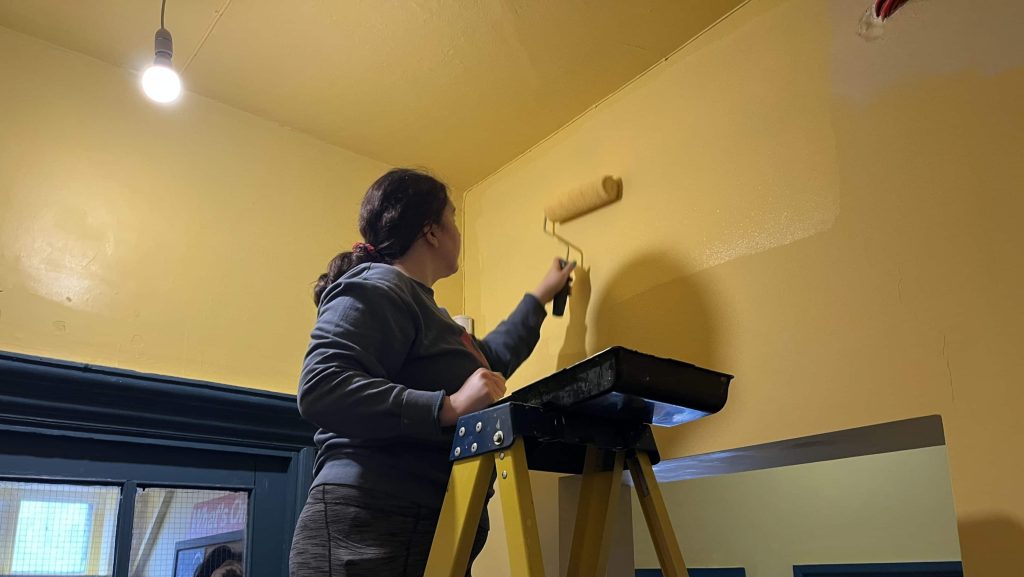 Volunteer decorating wall