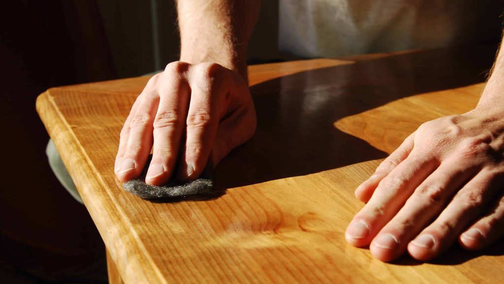Sanding a table ready to coat up again.